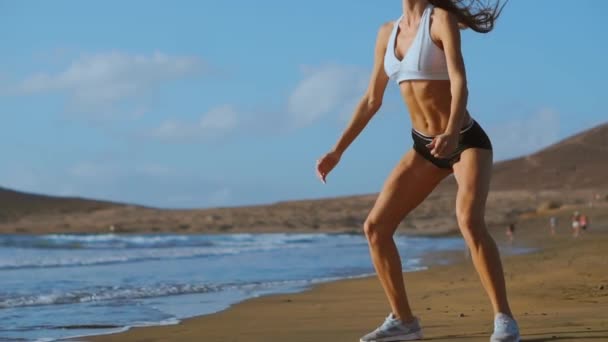 Meisje maken training been op het strand. Slow Motion Steadicam — Stockvideo