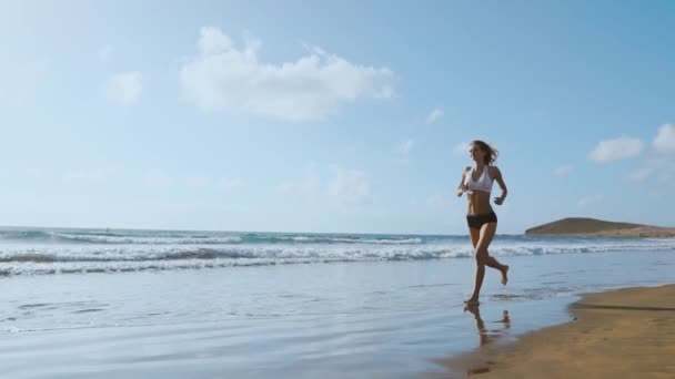 Τρέχοντας γυναίκα αθλήτρια τζόκινγκ κατά τη διάρκεια υπαίθρια προπόνηση στην παραλία., μοντέλο fitness σε εξωτερικούς χώρους. — Αρχείο Βίντεο