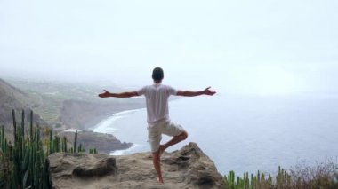 Uygun genç adam ocean için dağ Güneş selamlama yoga uygulamaları. Genç zevk meditasyon ve yoga adam. Fitness, spor, insanlar ve yaşam tarzı kavramı - yoga egzersizleri yapma genç adam.