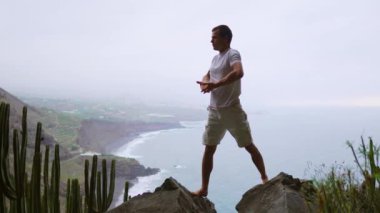 Uygun genç adam ocean için dağ Güneş selamlama yoga uygulamaları. Genç zevk meditasyon ve yoga adam. Fitness, spor, insanlar ve yaşam tarzı kavramı - yoga egzersizleri yapma genç adam.