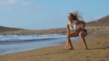 Kız spor şort ve tişört ile ağız kavgası atlar Kanarya Adaları'nda Okyanusu yakınlarındaki sahilde gerçekleştirir. Sağlıklı yaşam ve fitness tatil. Güzel ve sağlıklı vücut