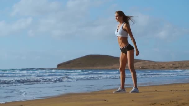 Joven hermosa mujer sexy haciendo deportes en la playa, amanecer, ejercicios matutinos, estilo de vida saludable, hacer ejercicio, hacer abdominales — Vídeos de Stock