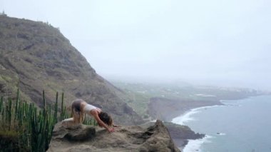 Genç kafkas kadın performans gösteren yukarı doğru bakan köpek poz açık havada