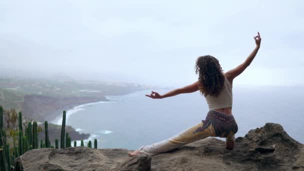 Una Mujer Sentada Borde Acantilado Una Pose Guerra Con Vistas — Vídeos de Stock