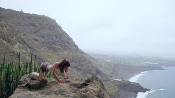 Jeune femme caucasienne effectuant vers le haut face à la pose de chien en plein air — Video