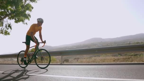 Man cykla på väg cykel utomhus träning på en tom väg på morgonen. Extrem sport koncept. slowmotion — Stockvideo