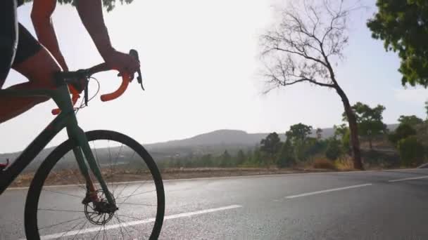 Hombre ciclismo en bicicleta de carretera ejercicio al aire libre en un camino vacío en la mañana. Concepto de deporte extremo. Movimiento lento — Vídeos de Stock