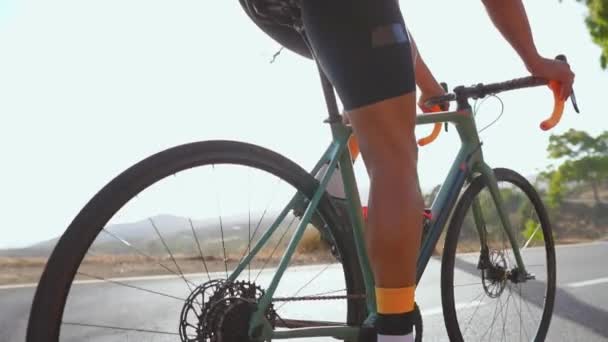 Man fietsen op de weg fiets buiten oefening op een lege weg in de ochtend. Extreme sport concept. Close - up, slow-motion — Stockvideo