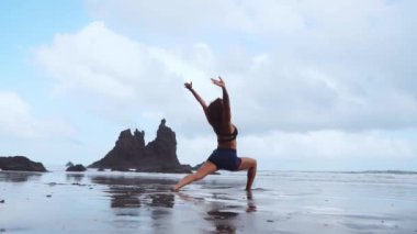 Mutlu genç kadın batımında sahilde Yoga uygulamak. Sağlıklı aktif yaşam tarzı kavramı. Ağır çekim