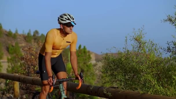 Un ciclista profesional se prepara para la llegada de paseos de entrenamiento de hombre de hierro en las montañas — Vídeo de stock