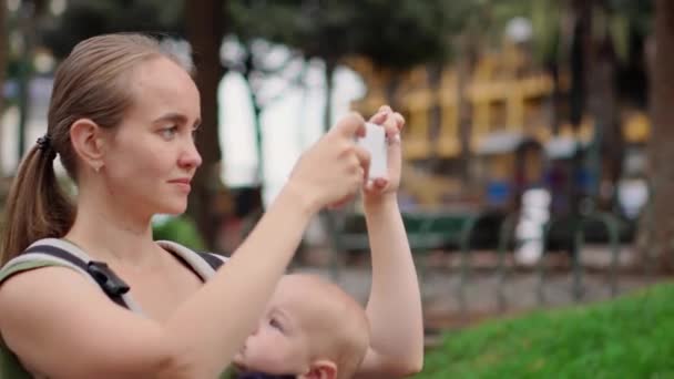 Uma mulher com um bebê viaja para a Espanha e tem uma bela visão em um telefone celular — Vídeo de Stock