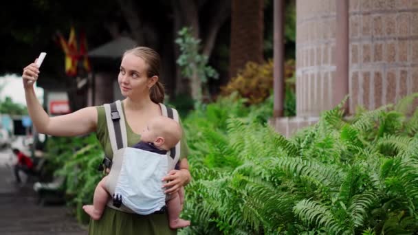 Jovem mãe com smartphone e bebê viajando . — Vídeo de Stock