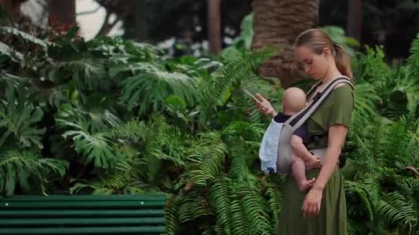 Smartphone ve bebek yolculuk ile Genç Anne. — Stok video