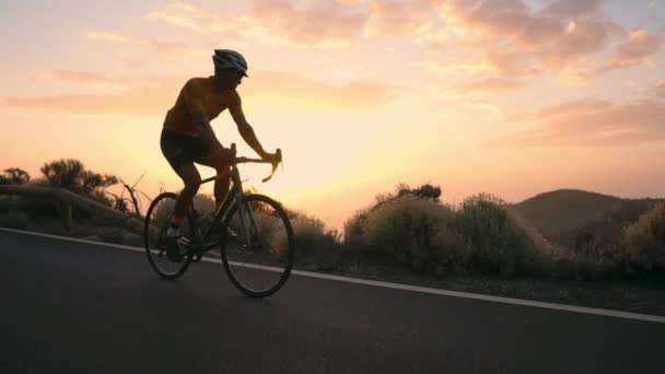 L'atleta su una bicicletta va da una roccia su una serpentina di montagna guardando una splendida vista dell'isola. Il concetto di uno stile di vita sano. Viaggi turistici in bicicletta — Video Stock