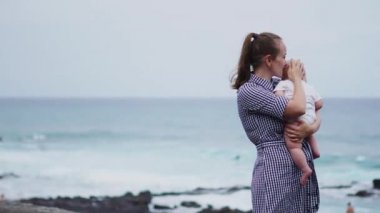 Tenerife, İspanya, Avrupa konusunda aile tatili. Anne ve bebek okyanus üzerinde açık havada. Portre seyahat turistler - çocuk ile anne. Olumlu insan duyguları, aktif yaşam tarzları. Mutlu genç aile deniz plaj