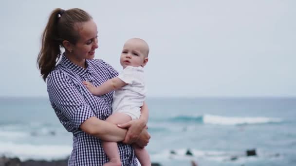 Οικογενειακές διακοπές σε Τενερίφη, Ισπανία, Ευρώπη. Η μητέρα και το μωρό έξω στον ωκεανό. Πορτρέτο τουρίστες ταξίδια - μαμά με το παιδί. Θετικά συναισθήματα ανθρώπου, δραστήριο τρόπο ζωής. Ευτυχισμένος νεαρή οικογένεια στην παραλία της θάλασσας — Αρχείο Βίντεο