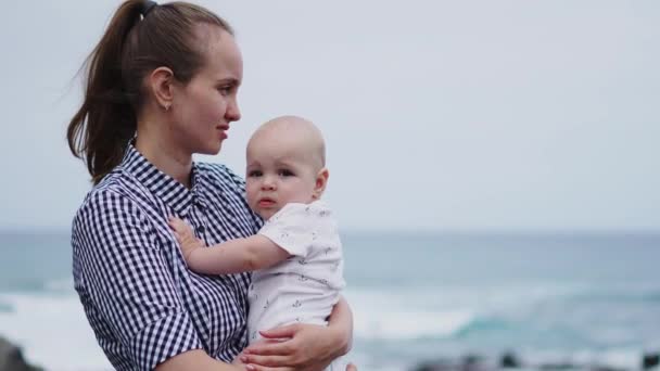 Οικογενειακές διακοπές σε Τενερίφη, Ισπανία, Ευρώπη. Η μητέρα και το μωρό έξω στον ωκεανό. Πορτρέτο τουρίστες ταξίδια - μαμά με το παιδί. Θετικά συναισθήματα ανθρώπου, δραστήριο τρόπο ζωής. Ευτυχισμένος νεαρή οικογένεια στην παραλία της θάλασσας — Αρχείο Βίντεο