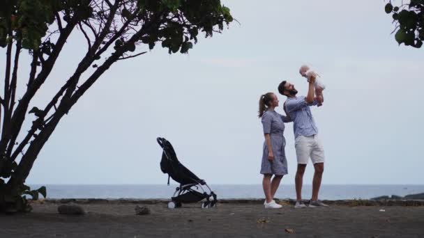 Bébé garçon penché sur son épaule papas pour toucher ludique nez avec sa belle mère souriante — Video