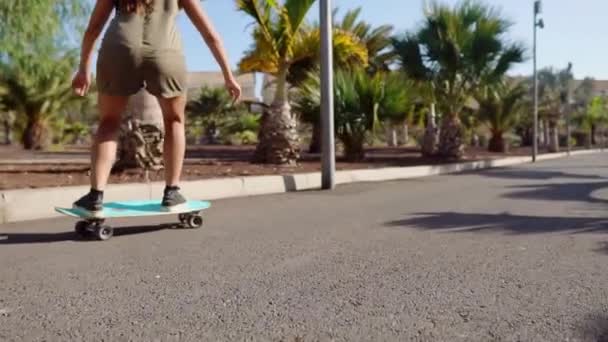 Joven chica paseos en carretera cerca de palmeras en longboard en cámara lenta — Vídeo de stock