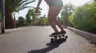 Island girl longboard üzerinde yaz kısa şort plaj ve palmiye ağaçları yakınındaki yolda rides