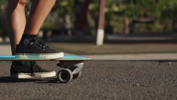 基板のスケーター足のクローズ アップ。スローモーションで道路に乗ってロングボード — ストック動画