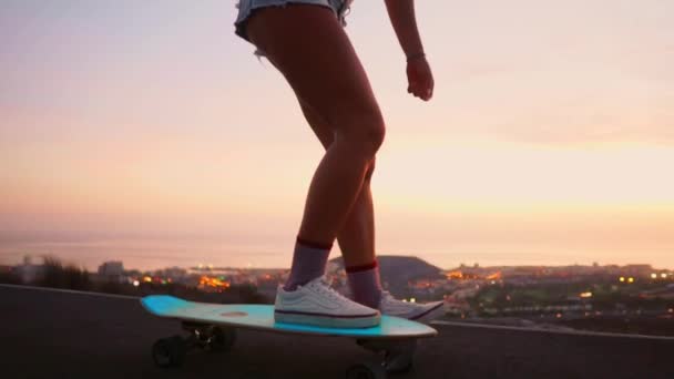 Дівчина катається на скейтборді біля океану і велика гора в повільному русі. Здоровий спосіб життя, Спорт . — стокове відео