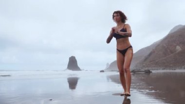 Su sporları yapmak için yürüyüş Okyanusu yakınlarındaki ince bir kadın her bacak lunges. Uyluk kas yavaş hareket için egzersizler