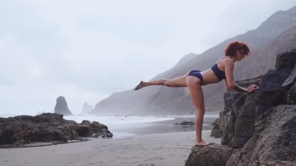 La femme mince sur la plage avec des sports de sable volcanique dans un très bel endroit — Video