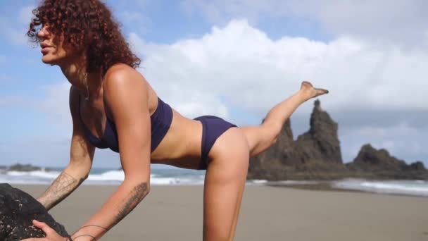 Menina do esporte em uma praia fazendo exercícios lunges. Conceito de um estilo de vida saudável . — Vídeo de Stock