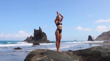 Kız bacak duran bir taş üzerinde dengeleme yoga yapıyor. İçiniz rahat olsun. Sağlıklı bir yaşam tarzı. Denge ve uyum