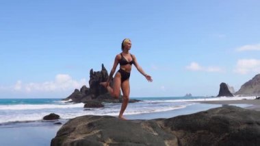 Kız bacak duran bir taş üzerinde dengeleme yoga yapıyor. İçiniz rahat olsun. Sağlıklı yaşam tarzı