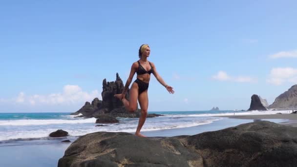 Kız bacak duran bir taş üzerinde dengeleme yoga yapıyor. İçiniz rahat olsun. Sağlıklı yaşam tarzı — Stok video