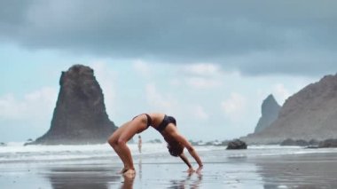 Sakin kız dağlarda, arka plandaki parlak güneş ışığı meditasyon yapıyor. Ağır çekimde video. Tenerife zamanında Yoga