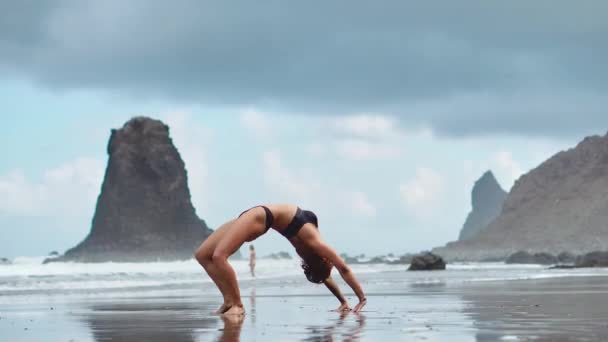 穏やかな女の子は、背景に明るい日差しの中、山で瞑想中です。スローモーション動画。テネリフェ島でのヨガの時間 — ストック動画