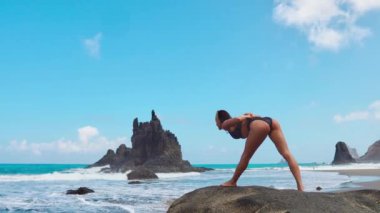 Sakin kız dağlarda, arka plandaki parlak güneş ışığı meditasyon yapıyor. Ağır çekimde video. Tenerife zamanında Yoga