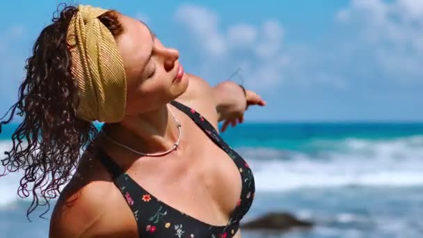 岩と波の背景に黒砂のビーチでの女性トレーニング腹部筋肉をスポーツします — ストック動画