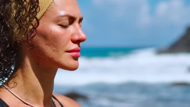 Serene meditation yoga. Brunett turist kvinna mediterar i lotusställning på udde ovanför vackra Praia da Marinha. Mediterar kvinna på klipporna över Kanarieöarna — Stockvideo