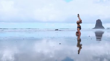 Yaz gündoğumu yoga seansı güzel Playa de La Tejita plajda Punta Roja rock - tropik Tenerife ada, Kanarya İspanya ve Atlantik Okyanusu manzaralı. Desteklenen başı, Sirasana Sirsasana