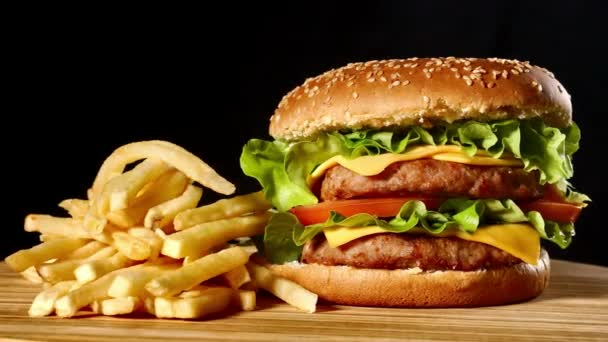 Artesanato hambúrguer de carne e batatas fritas, molho isolado em fundo preto. fast food — Vídeo de Stock