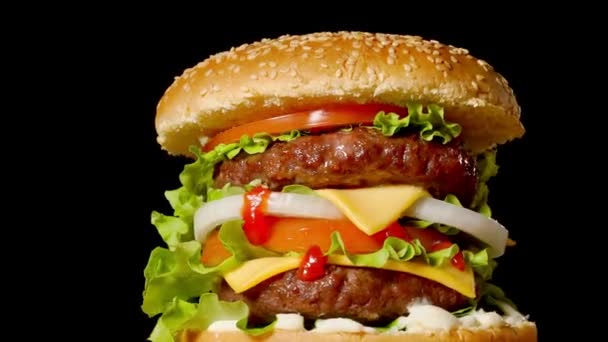 Primer plano de hamburguesas de carne caseras con lechuga y mayonesa servidas en una pequeña tabla de cortar de madera. Fondo oscuro — Vídeo de stock