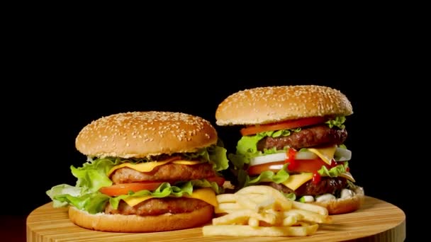 Dois hambúrgueres artesanais de carne na mesa de madeira isolados em fundo cinza escuro . — Vídeo de Stock