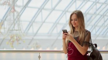 Telefon alışveriş merkezinde, bakarken gülümseyen çanta satın almalarla, holding mutlu genç kız. İyi haber, okuma mesaj, mesaj aldı. Yatay fotoğraf banner web sitesi header tasarımı için