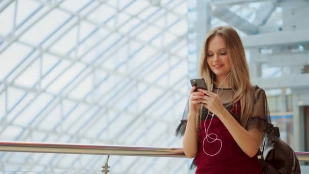 Blogger sonriente escuchando canciones favoritas en auriculares mientras posa para selfie en la cámara del teléfono inteligente, chica hipster disfrutando de la transmisión de radio haciendo foto para la imagen en las redes sociales en el móvil . — Vídeo de stock