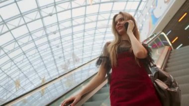 Arkadaşlarınızla sohbet haber, tarama, genç gülümseyen kadın mavi tişört ayakta smartphone, kullanarak alışveriş merkezinde okuma