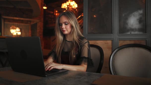 Gelukkig jonge vrouw drinken koffie en het gebruik van tablet pc in café — Stockvideo