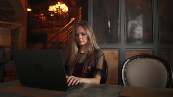 Όμορφη γυναίκα που εργάζονται για το laptop της για ένα κομψό αστικό εστιατόριο — Αρχείο Βίντεο