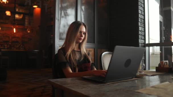 Šťastná mladá žena pití kávy a použití tabletového počítače v kavárně — Stock video