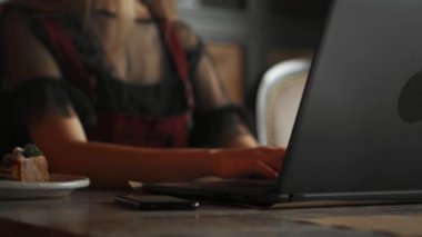 Dizüstü bilgisayar kullanan smartwatch giyen genç kadın. Açık bir kafede dizüstü bilgisayar üzerinde çalışan erkek.