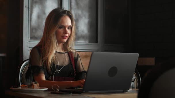 Joyeux jeune femme boire du café et en utilisant un ordinateur tablette dans le café — Video