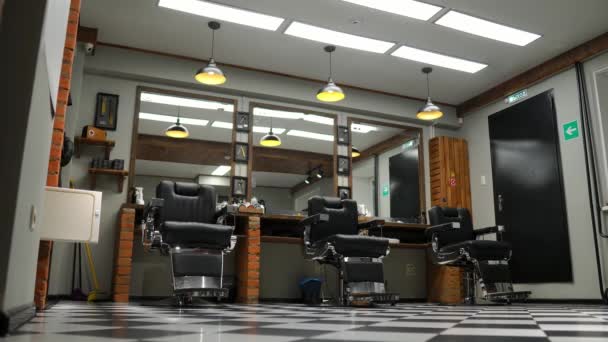 Vintage hanging lamps in hairdressing salon. Ceiling retro lamp in barber shop. Barber pole. Hair salon interior. Metal ceiling lights in barbershop — Stock Video